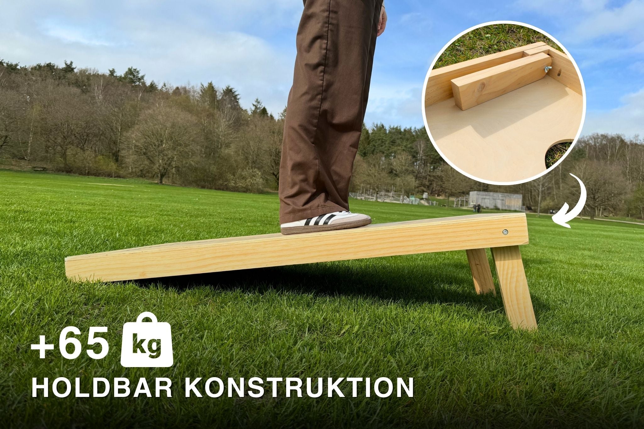 Person stÄr ovenpÄ et cornholespil i de officielle mÄl 120x60 fra cornhole.dk for at teste holdbarheden og personen vejer 65 kg, hvilket viser at spillet er ekstremt robust.